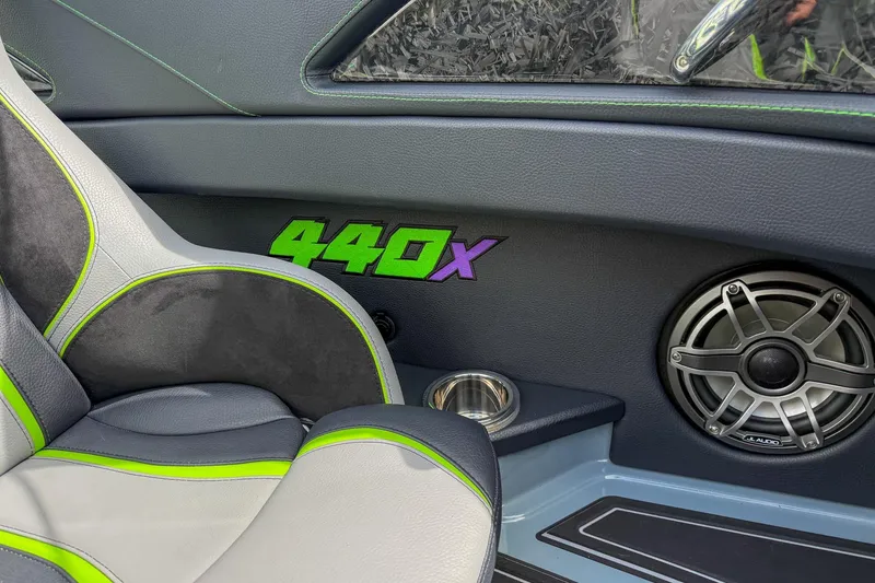 Slide: The Image of Interior of 2024 MTI 440X boat with speaker and green-accented seat. - 11