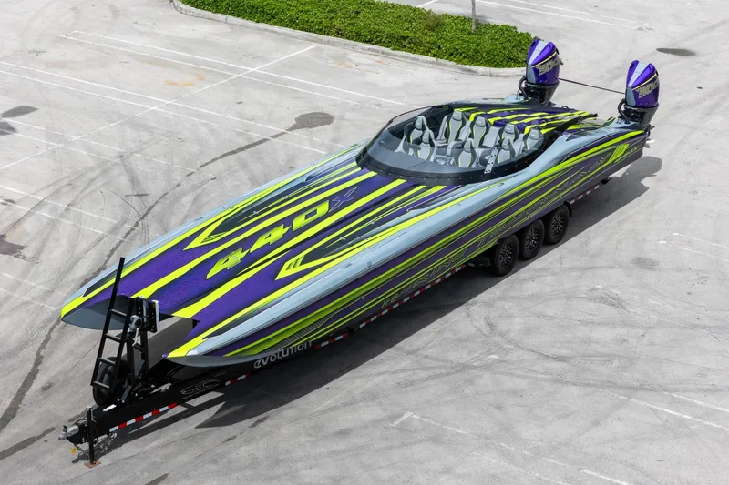 Slide: The Image of 2024 MTI 440X powerboat with vibrant purple and green design on a trailer. - 14
