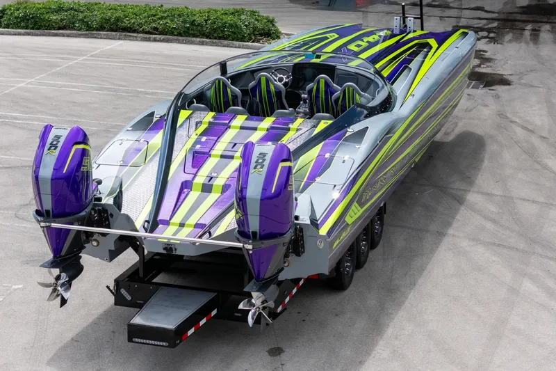 Slide: The Image of 2024 MTI 440X powerboat with vibrant purple and green design on a trailer. - 15