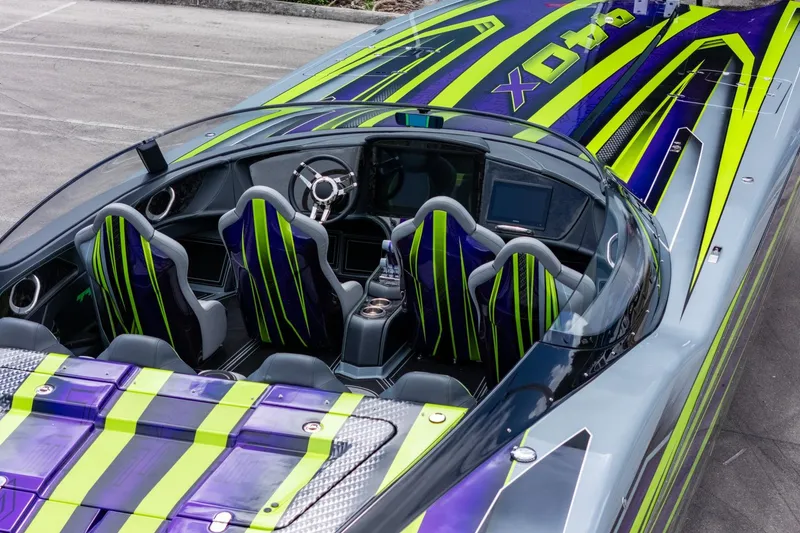 Slide: The Image of 2024 MTI 440X speedboat with vibrant green and purple design, featuring sleek seating and modern dashboard. - 17