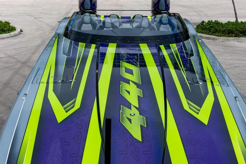 Slide: The Image of 2024 MTI 440X speedboat with vibrant green and purple design, top view. - 20