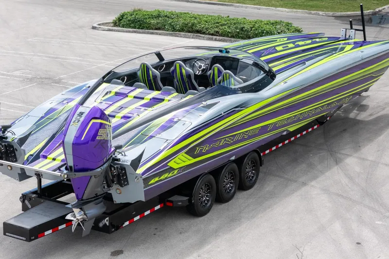 Slide: The Image of 2024 MTI 440X powerboat with vibrant purple and green design on a trailer. - 4