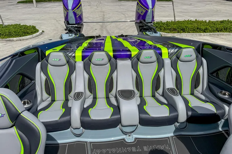 Slide: The Image of 2024 MTI 440X boat interior with sleek gray and green seats, vibrant design. - 9