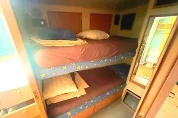 Slide: The Image of Bunk beds in 1996 Buddy Davis 67 yacht cabin, featuring cozy bedding and wooden accents. - 15