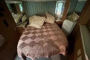 Slide: The Image of Cozy bedroom in 1996 Buddy Davis 67 yacht with patterned bedding and mirrored accents. - 16