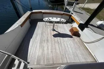 Slide: The Image of Spacious deck of 1996 Buddy Davis 67 yacht with wooden flooring and fishing table. - 8