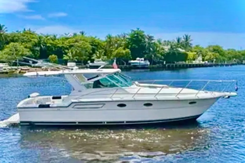 The Image of 2000 Tiara 37 Open yacht cruising on a sunny day, surrounded by lush greenery. - 0