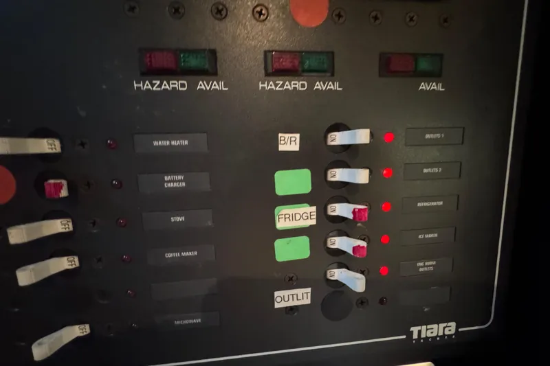 Slide: The Image of Control panel of a 2000 Tiara 37 Open boat with labeled switches and indicators. - 105