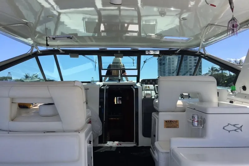 Slide: The Image of Interior view of a 2000 Tiara 37 Open yacht with white seating and helm. - 13