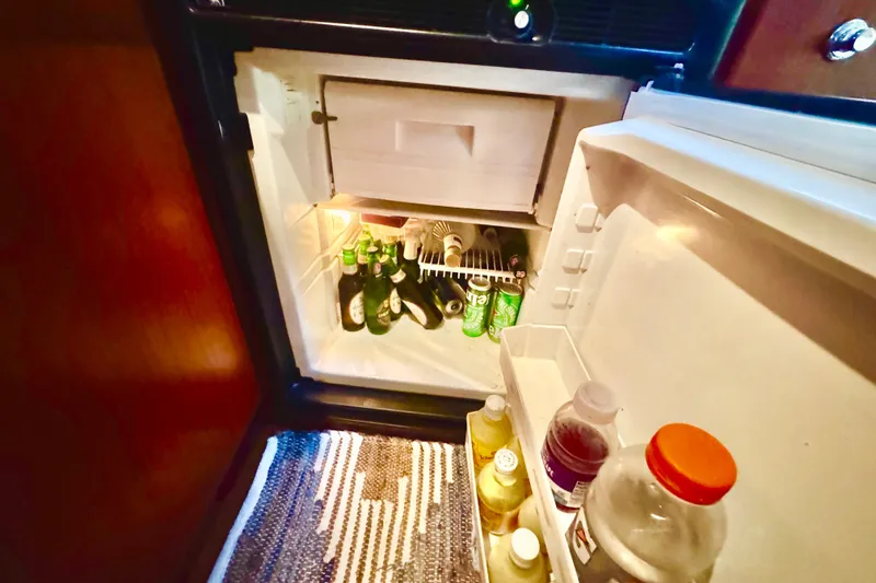 Slide: The Image of Mini fridge stocked with beverages inside a 2000 Tiara 37 Open yacht. - 39