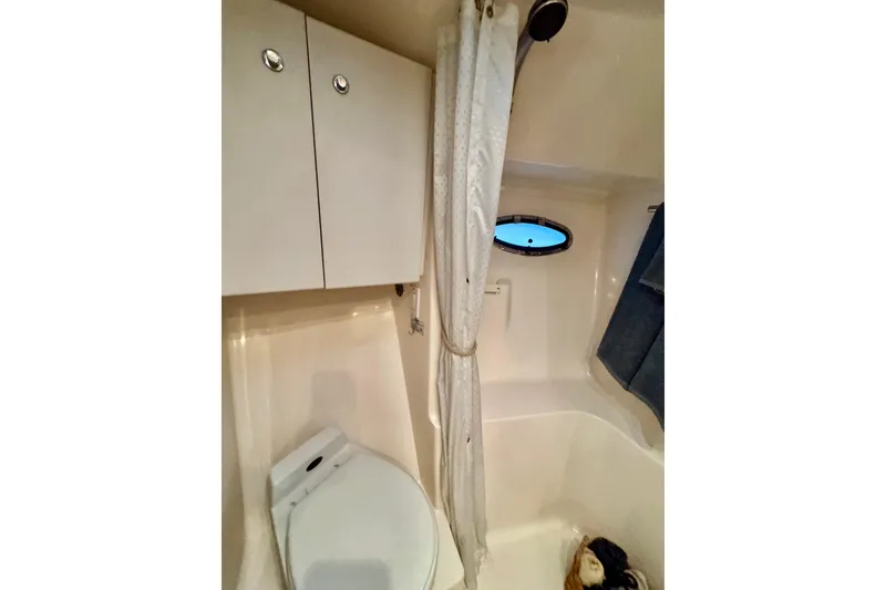 Slide: The Image of Bathroom interior of 2000 Tiara 37 Open yacht, featuring toilet, cabinets, and porthole. - 47
