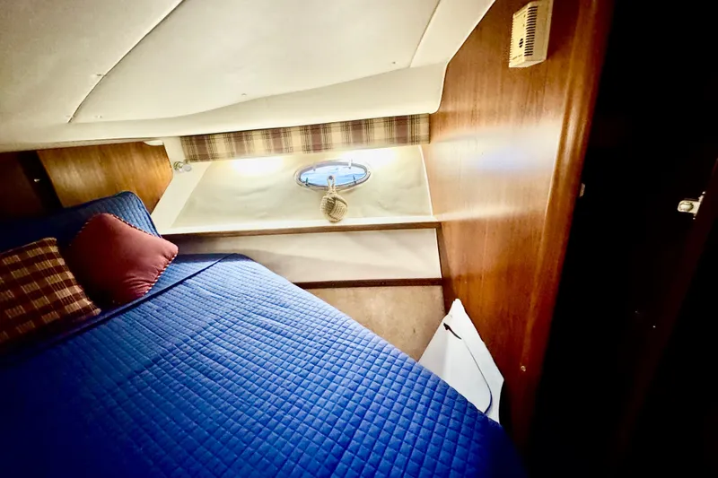 Slide: The Image of 2000 Tiara 37 Open cabin interior with blue bedding and wood paneling. - 53