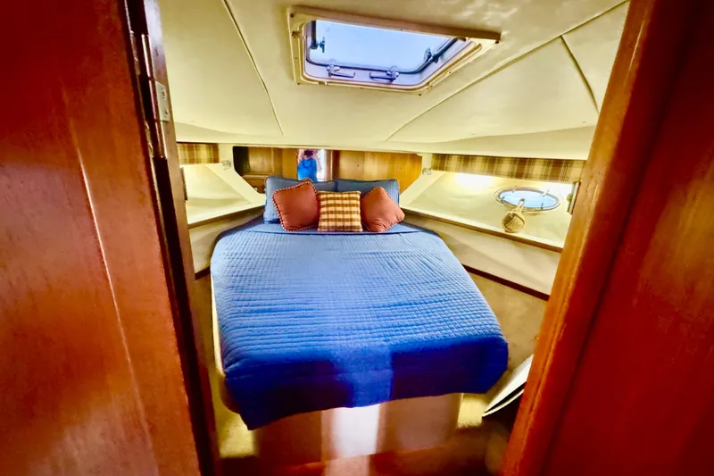 Slide: The Image of Cozy cabin interior of 2000 Tiara 37 Open yacht with blue bedding and porthole. - 55