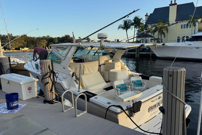 Slide: The Image of 2000 Tiara 37 Open yacht docked at marina with fishing gear and scenic waterfront view. - 63