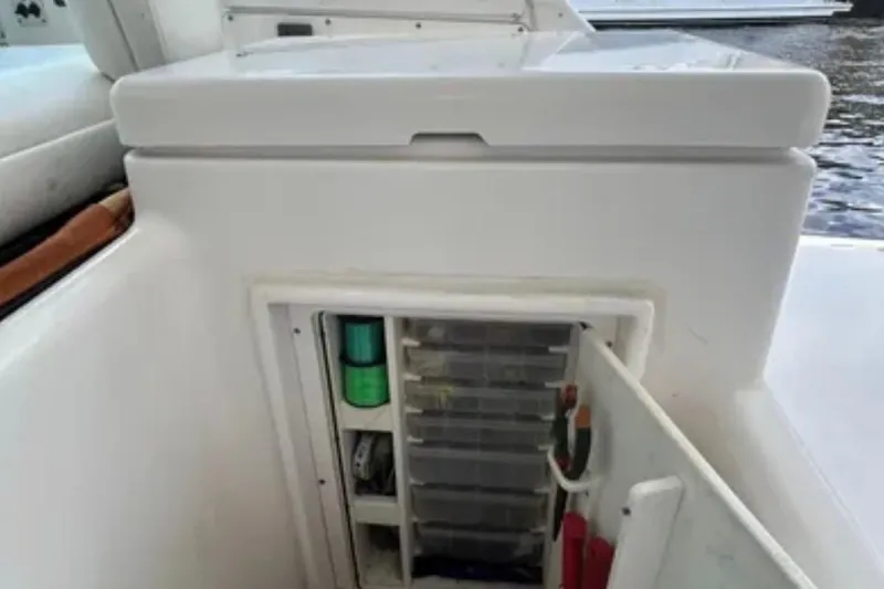 Slide: The Image of Storage compartment on a 2000 Tiara 37 Open boat, featuring organized fishing gear. - 82