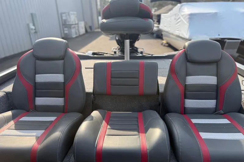 Slide: The Image of 2021 Ranger RT188 boat seats with gray, red, and white upholstery in a marina setting. - 11