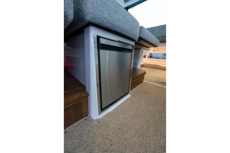 Slide: The Image of 2027 Axopar 38 Cross Cabin interior with compact stainless steel fridge under seating. - 15