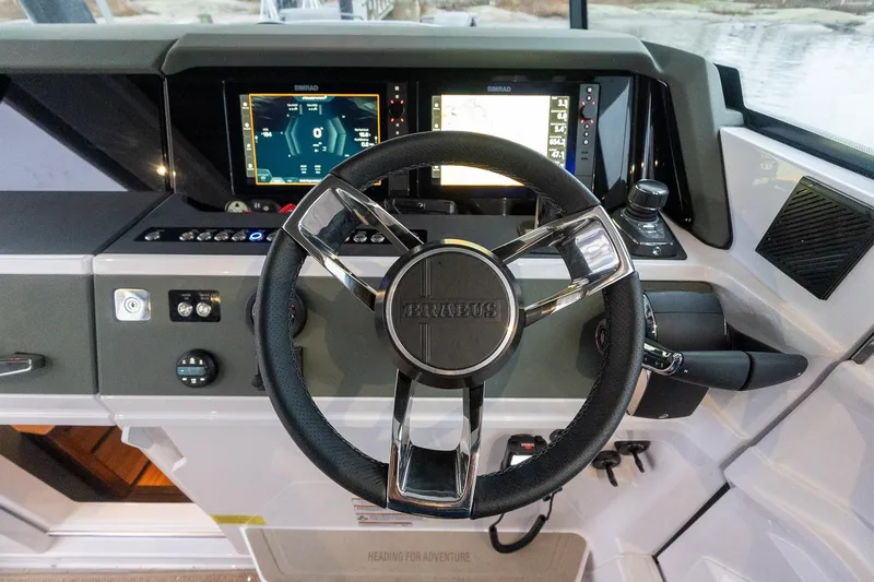 Slide: The Image of Steering wheel and dashboard of 2027 Axopar 38 Cross Cabin boat with navigation screens. - 20