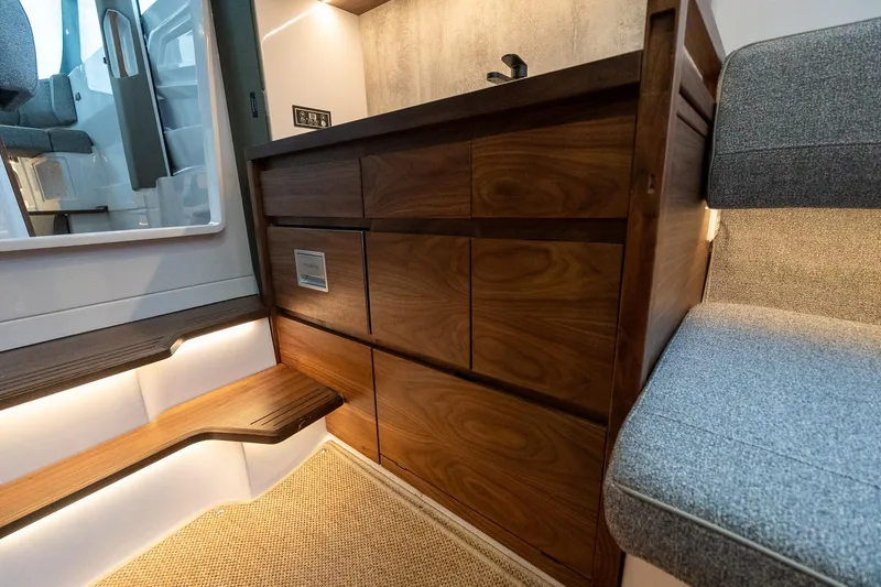 Slide: The Image of 2027 Axopar 38 Cross Cabin interior with wooden cabinetry and modern seating. - 41