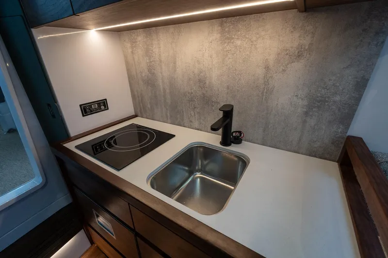 Slide: The Image of Modern kitchenette in 2027 Axopar 38 Cross Cabin with sink and induction cooktop. - 42