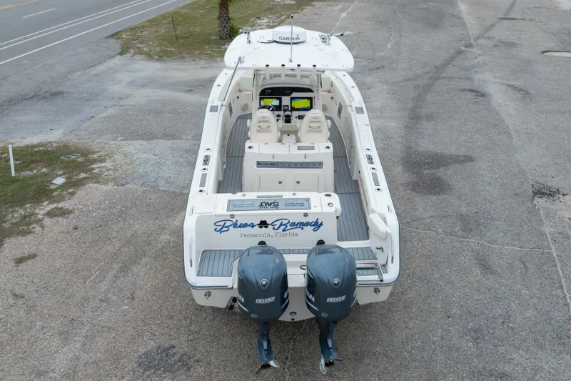 Slide: The Image of 2017 Grady-White Canyon 306 boat with dual Yamaha engines, parked on a concrete surface. - 18