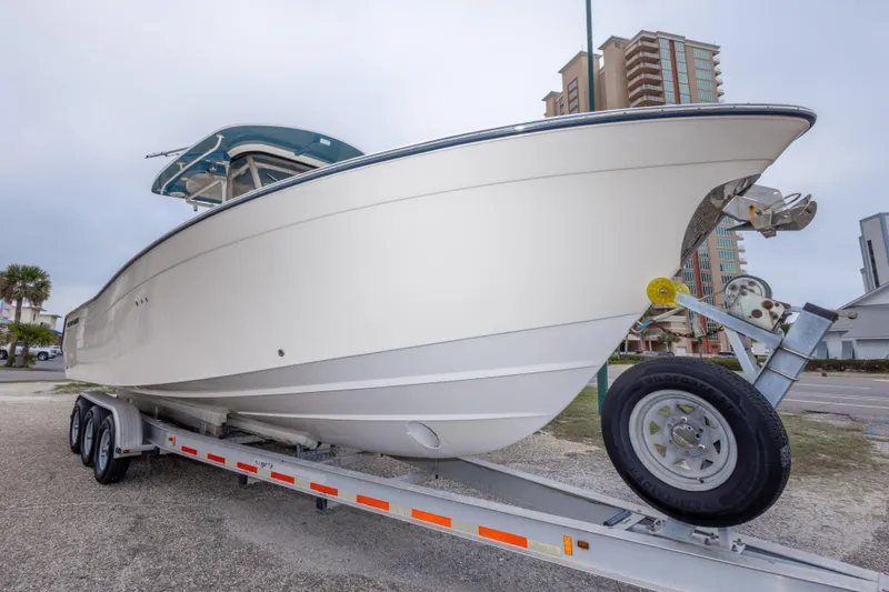 Slide: The Image of 2017 Grady-White Canyon 306 boat on trailer, urban background, overcast sky. - 2