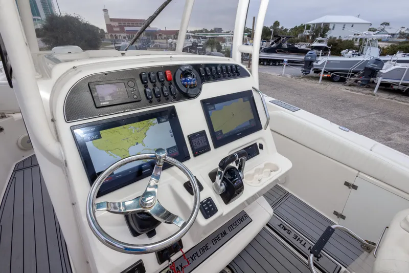 Slide: The Image of 2017 Grady-White Canyon 306 boat dashboard with navigation screens and steering wheel. - 24