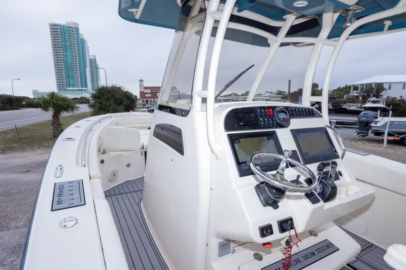 Slide: The Image of 2017 Grady-White Canyon 306 boat dashboard with modern controls, parked near coastal buildings. - 32
