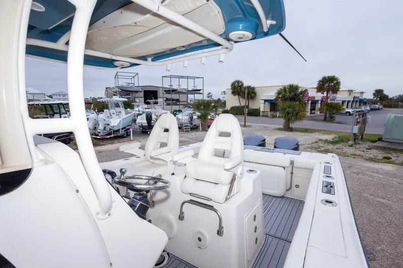 Slide: The Image of 2017 Grady-White Canyon 306 boat interior with helm and seating, parked near a marina. - 34