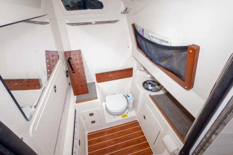 Slide: The Image of 2017 Grady-White Canyon 306 boat interior with compact bathroom and wooden accents. - 36