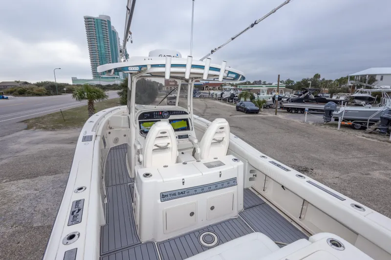 Slide: The Image of 2017 Grady-White Canyon 306 boat with dual helm seats, docked near a coastal road. - 43