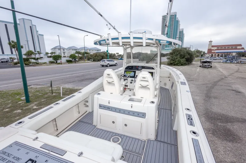 Slide: The Image of 2017 Grady-White Canyon 306 boat docked near a coastal road with buildings. - 44