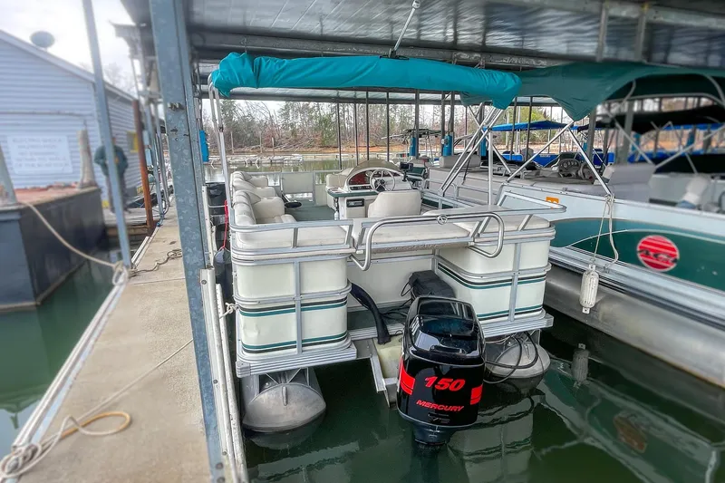 Slide: The Image of 2000 Crest 25' Pontoon boat with Mercury 150 engine docked in marina. - 10