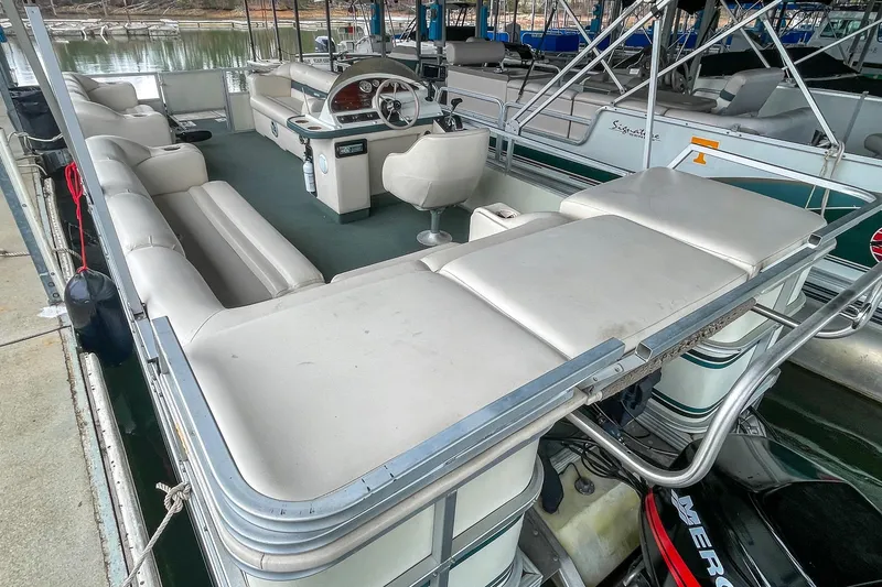 Slide: The Image of 2000 Crest 25' Pontoon boat with spacious seating and modern helm, docked at marina. - 11