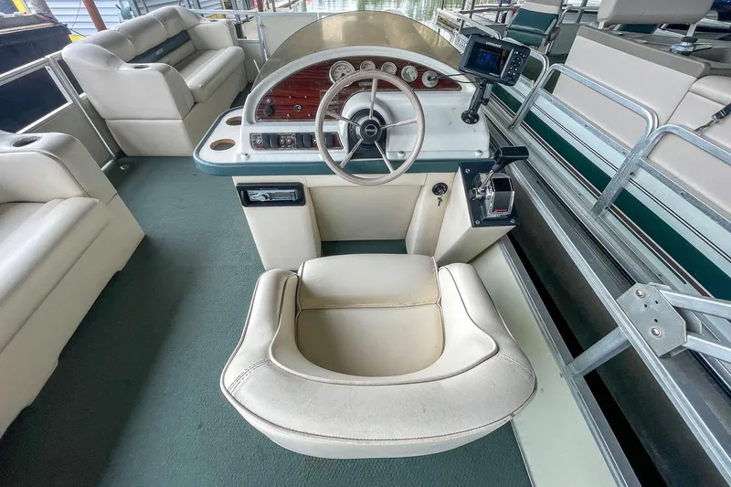 Slide: The Image of 2000 Crest 25' Pontoon boat interior with steering console and seating. - 16