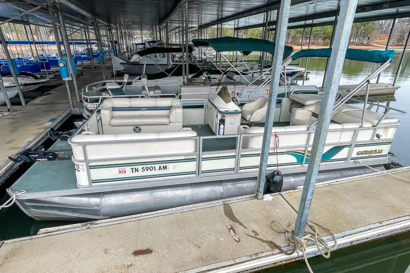 Slide: The Image of 2000 Crest 25' Pontoon boat docked in a marina, featuring spacious seating and canopy. - 22