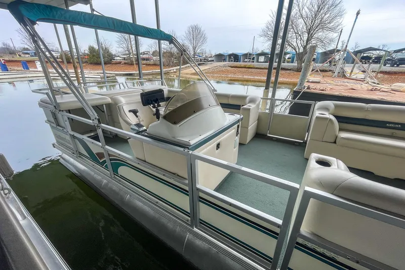 Slide: The Image of 2000 Crest 25' Pontoon boat docked, featuring spacious seating and a canopy. - 24