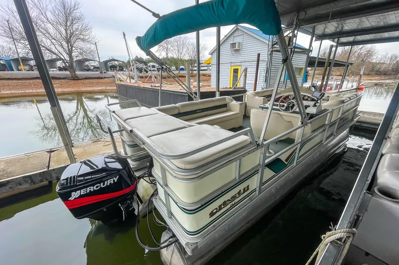 Slide: The Image of 2000 Crest 25' Pontoon boat docked with Mercury outboard motor. - 25