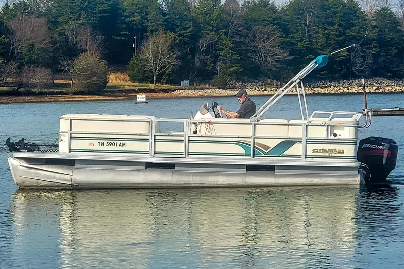 Slide: The Image of 2000 Crest 25' Pontoon boat on a calm lake with trees in the background. - 3