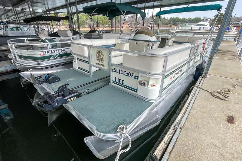 Slide: The Image of 2000 Crest 25' Pontoon boat docked in a marina, featuring comfortable seating and canopy. - 6