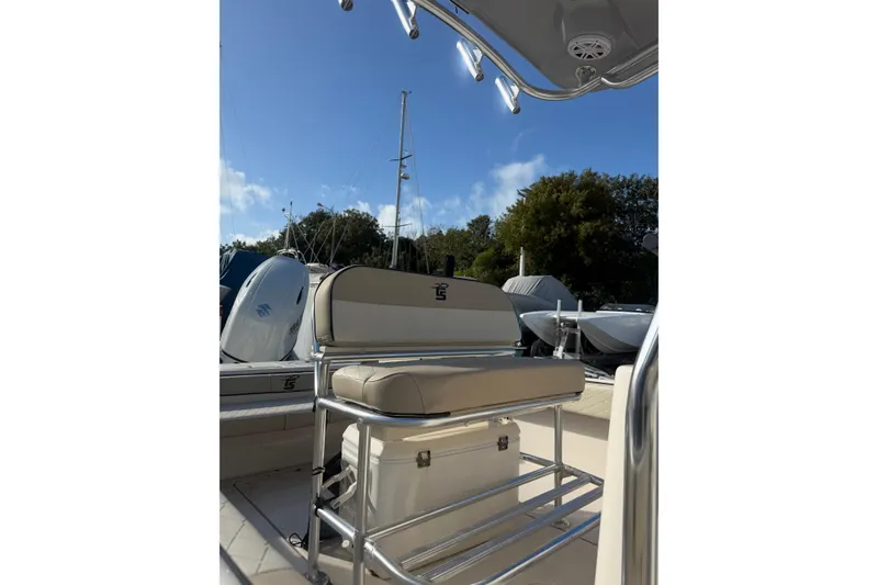 Slide: The Image of 2022 Carolina Skiff 23 UE boat interior with seating and storage, under clear blue sky. - 10