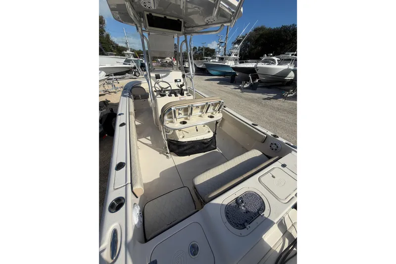 Slide: The Image of 2022 Carolina Skiff 23 UE boat interior with seating and console, docked outdoors. - 12