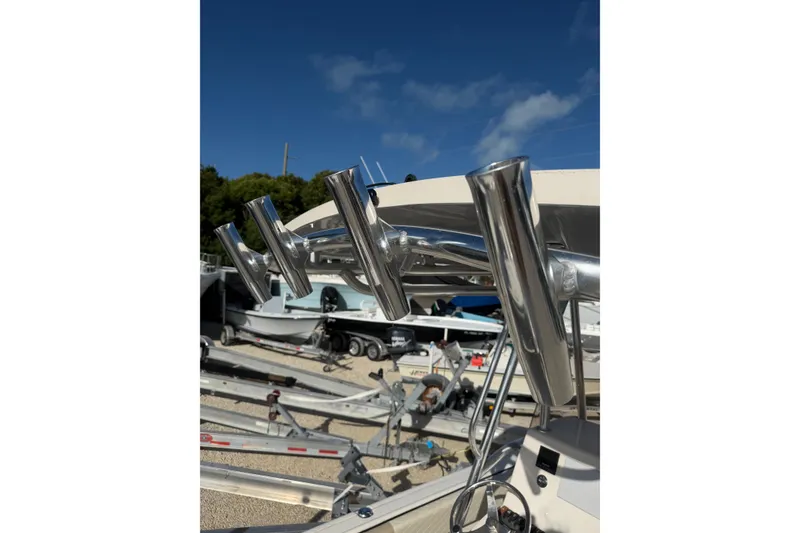 Slide: The Image of 2022 Carolina Skiff 23 UE boat with stainless steel rod holders under clear blue sky. - 14