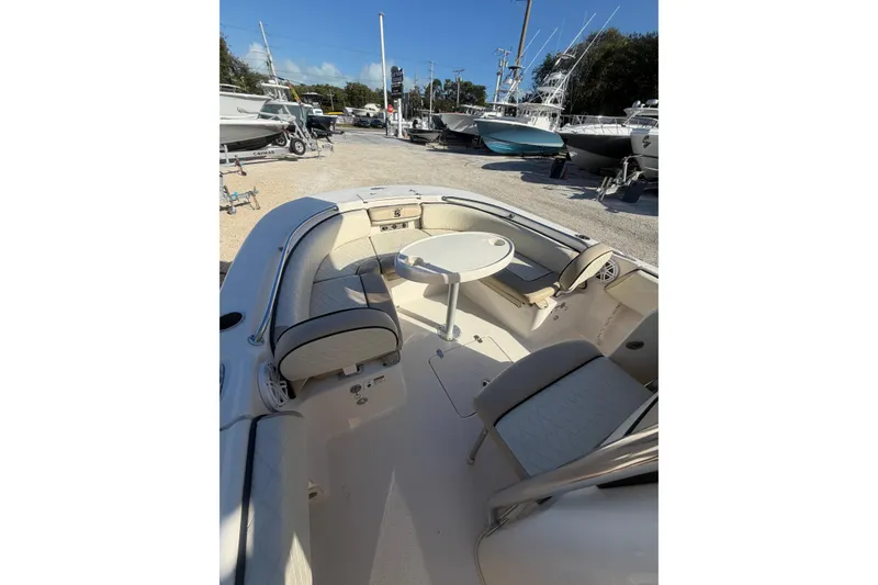 Slide: The Image of 2022 Carolina Skiff 23 UE boat interior with seating and table, displayed outdoors. - 22