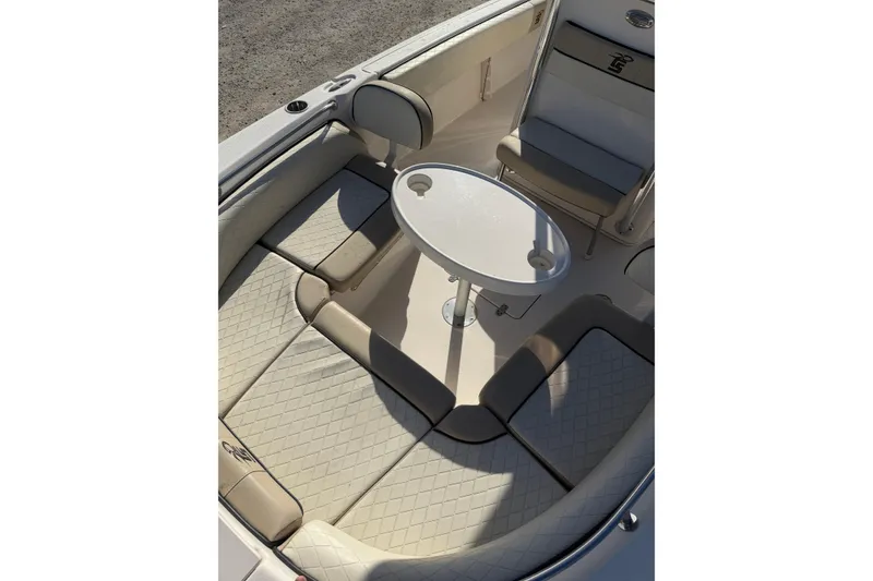 Slide: The Image of 2022 Carolina Skiff 23 UE boat interior with cushioned seating and round table. - 27