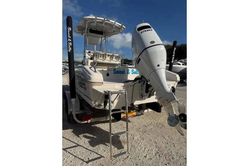 Slide: The Image of 2022 Carolina Skiff 23 UE boat with outboard motor and ladder, parked on a trailer. - 3