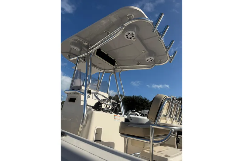 Slide: The Image of 2022 Carolina Skiff 23 UE boat console with T-top and seating under clear blue sky. - 6