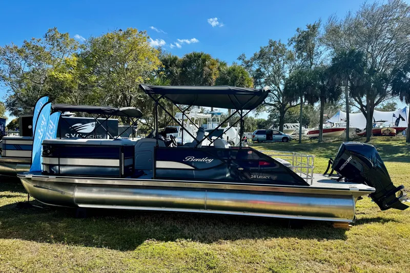 The Image of 2026 Bentley Pontoons Legacy 243 Swingback displayed outdoors with trees and boats in the background. - 1