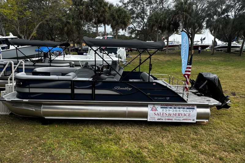 Slide: The Image of 2026 Bentley Pontoons Legacy 243 Swingback displayed outdoors with sales banner. - 6