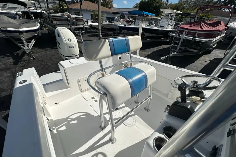 Slide: The Image of 1998 Bluewater 2150 boat interior with seating and steering wheel, displayed in a marina. - 10